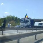 VIDEO Sensul către Bucureşti al A1, blocat – Un şofer a oprit vehiculul de mare tonaj de-a latul şoselei şi s-a urcat pe cabină, fluturând steagul României UPDATE Screenshot 2025 07 20 at 15.35.32