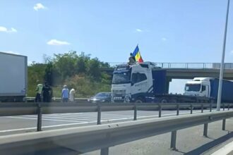 VIDEO Sensul către Bucureşti al A1, blocat – Un şofer a oprit vehiculul de mare tonaj de-a latul şoselei şi s-a urcat pe cabină, fluturând steagul României UPDATE Screenshot 2025 07 20 at 15.35.32